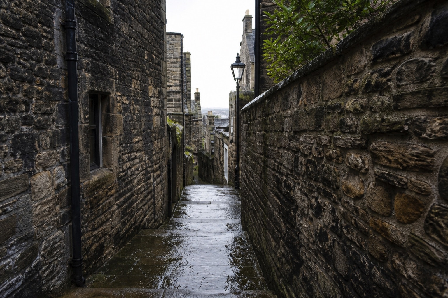 Rain-darkened stone steps leading through a narrow Edinburgh close